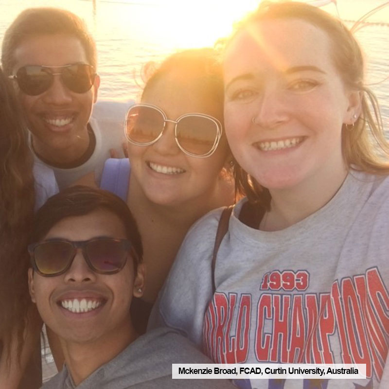 Ryerson FCAD student, Mckenzie Broad, poses with friends in front of a sunset while on exchange at Curtin University, Australia.
