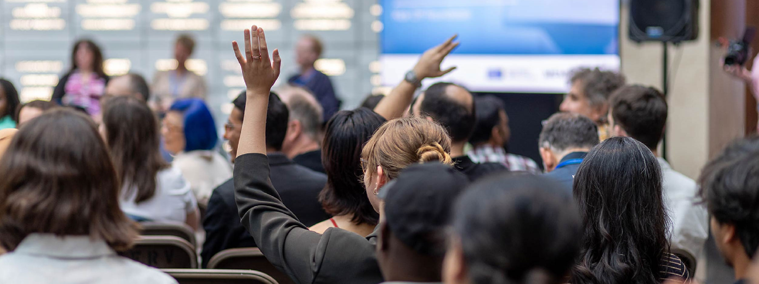 Audience member asking a question to a panel on stage