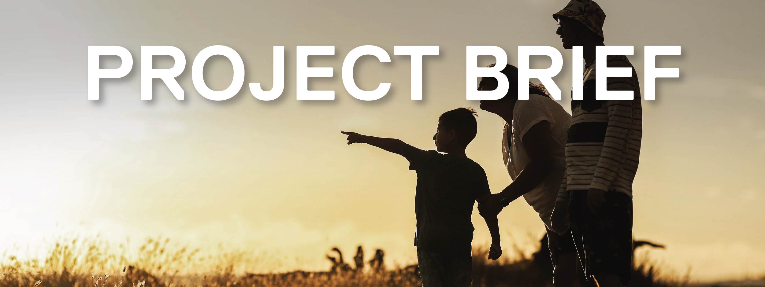 A small child, mother, and father stand in nature looking at a sunset together