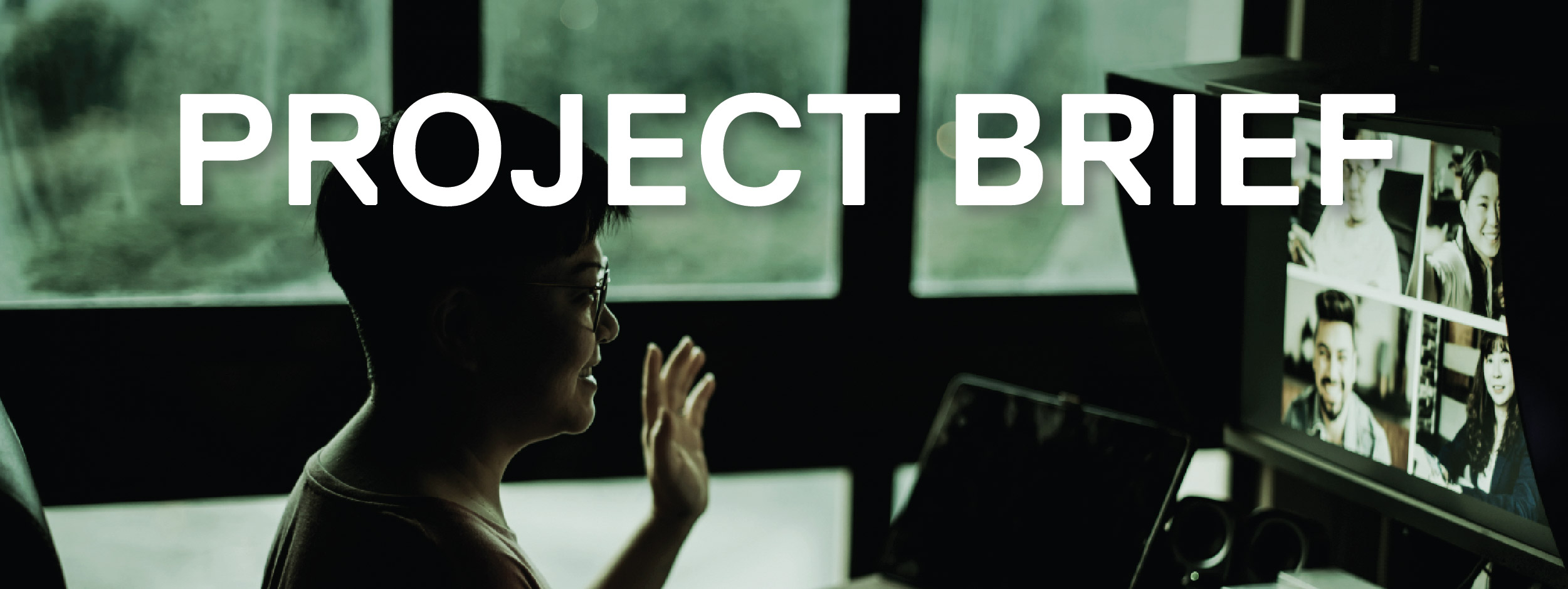 Woman at a desk talking to people virtually on a computer monitor