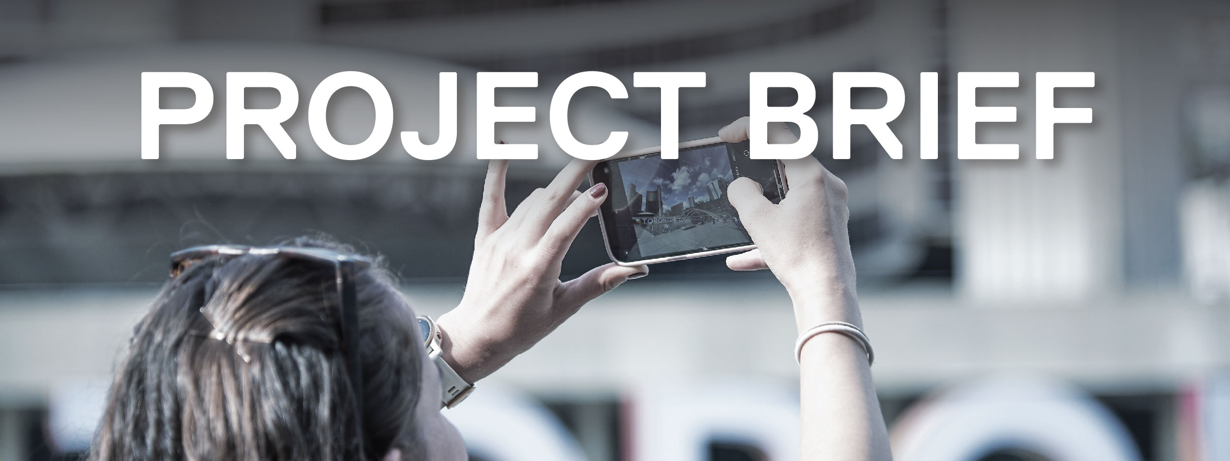 Woman taking a photo on a cell phone in downtown Toronto