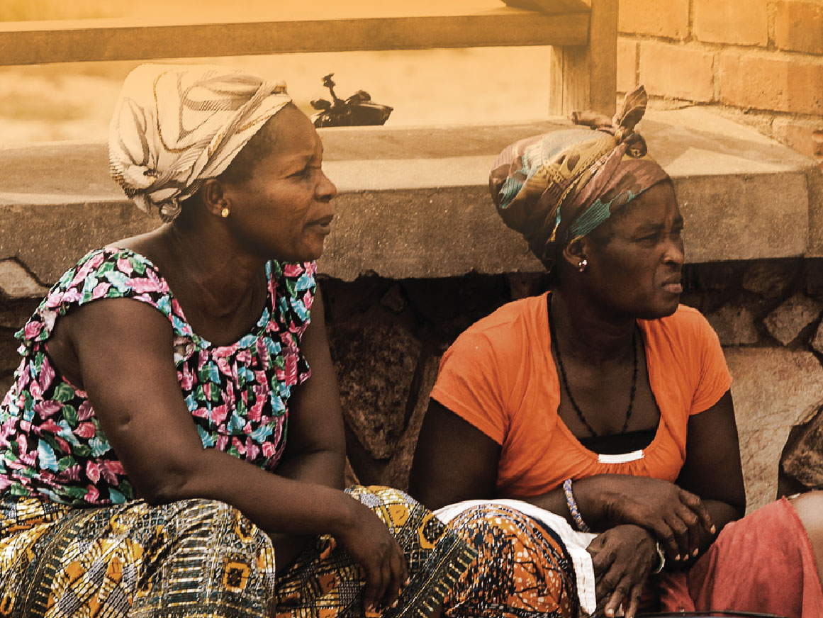 Unidentified Ghanaian women sit on a buckets in Elmina port