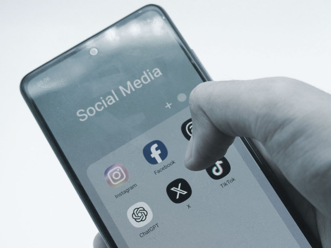 Person holding a cell phone with social media applications on the screen