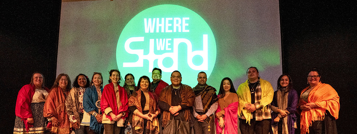 WhereWeStand Cohort standing in front of the program's logo