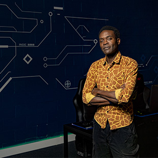 Black man wearing patterned orange and yellow dress shirt