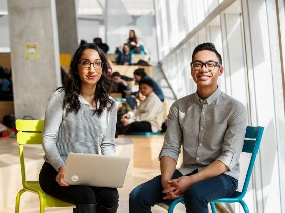 Students sit on chairs in the SLC building.