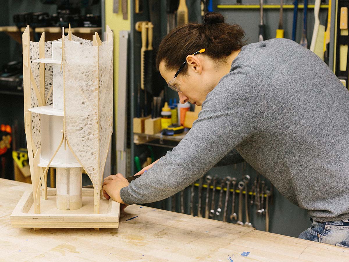 Student working on an architectural model in lab