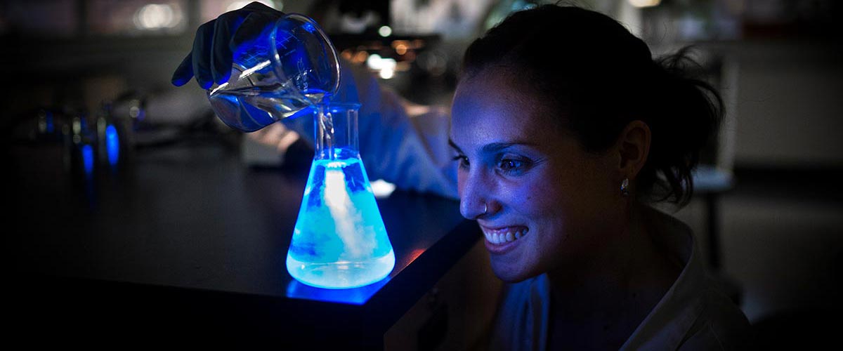 Leslie Bone working with fluorescent liquids in molecular lab