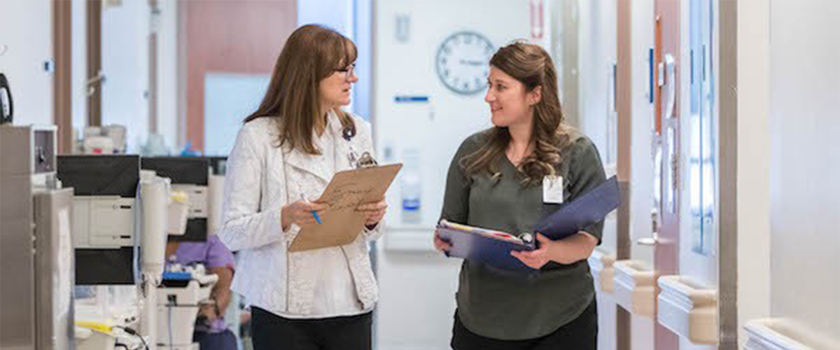 Two nursing students talking in a hospital corridor