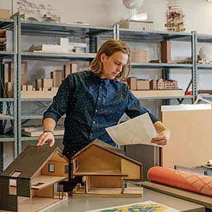 Grad student with building models and blueprints