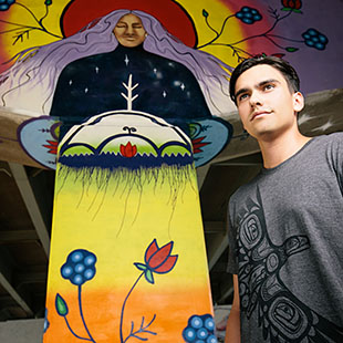 PhD student Riley Kucheran with Sky Woman painting, by Chief Lady Bird and Aura with Mural Routes