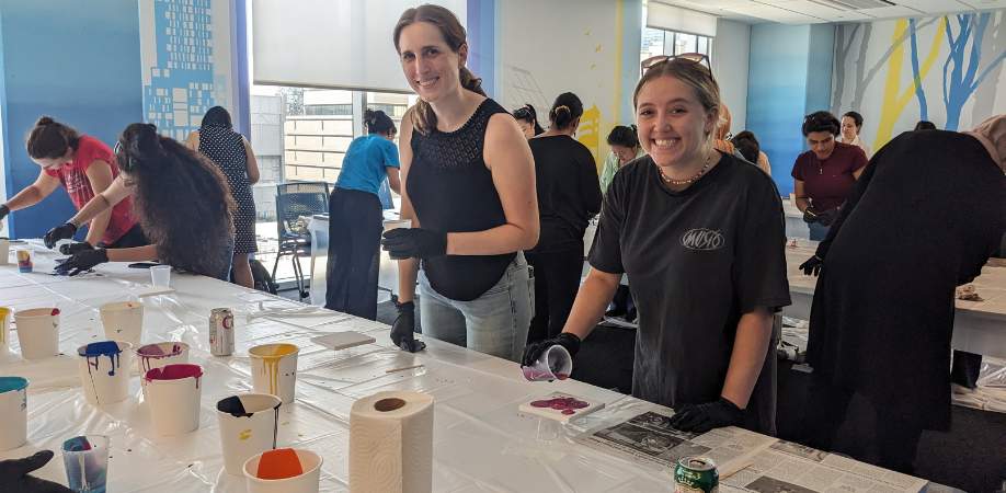 Two female graduate students making acrylic pour painting