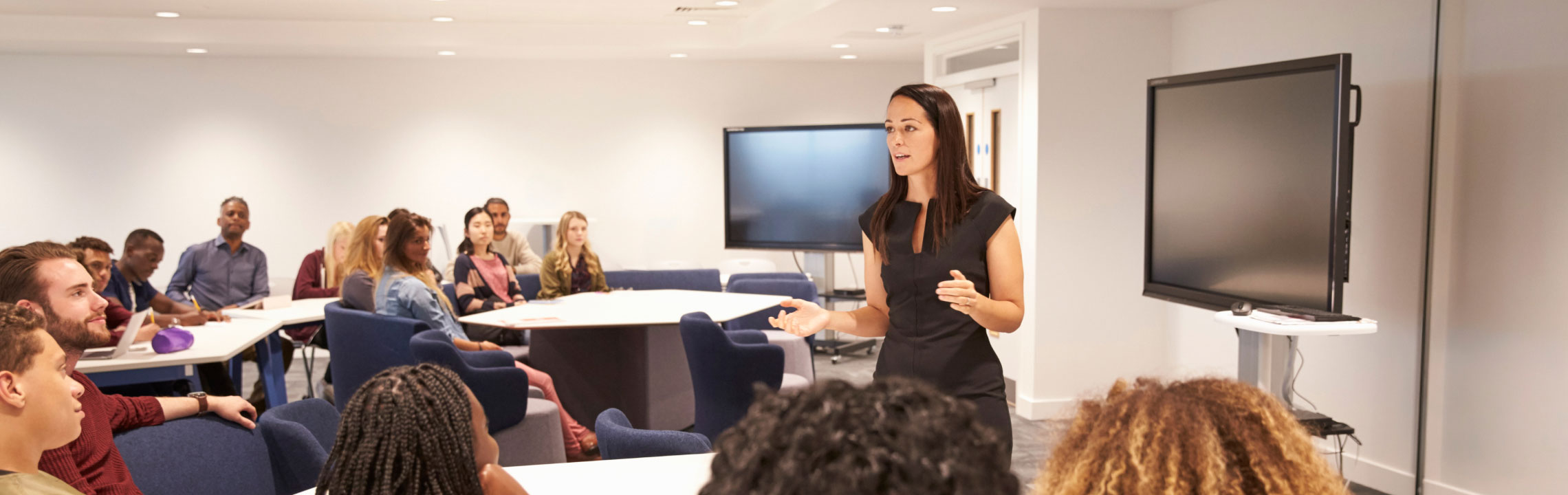 Presenter speaking to a group during a session in a classroom. 