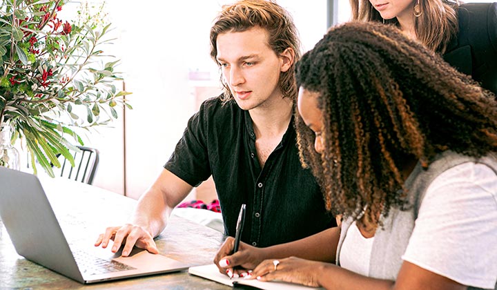 3 students working around a laptop