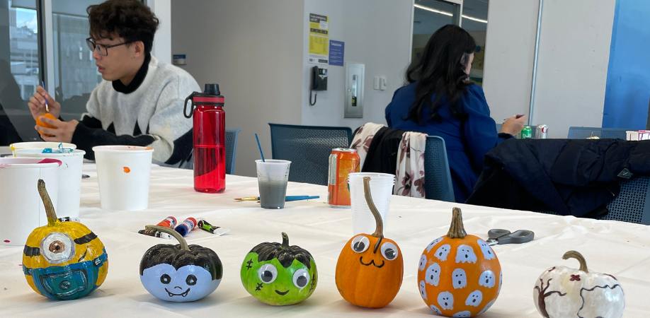 Six painted jack-o-lanterns in a line displayed on table