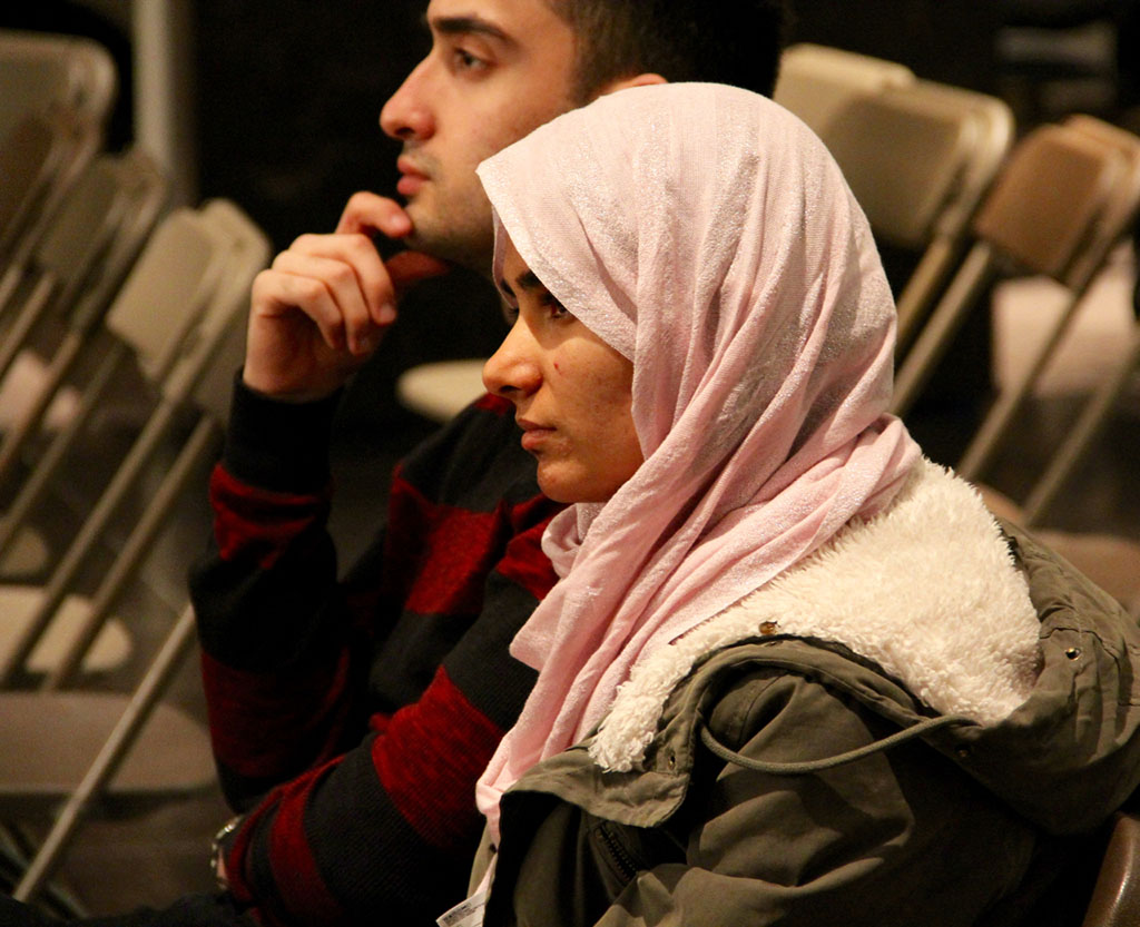 Female and male graduate students listening to presenter