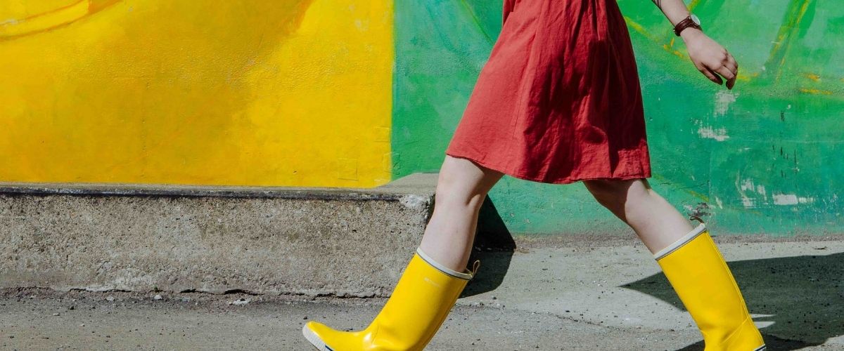 A women in a red dress with yellow rainboots.