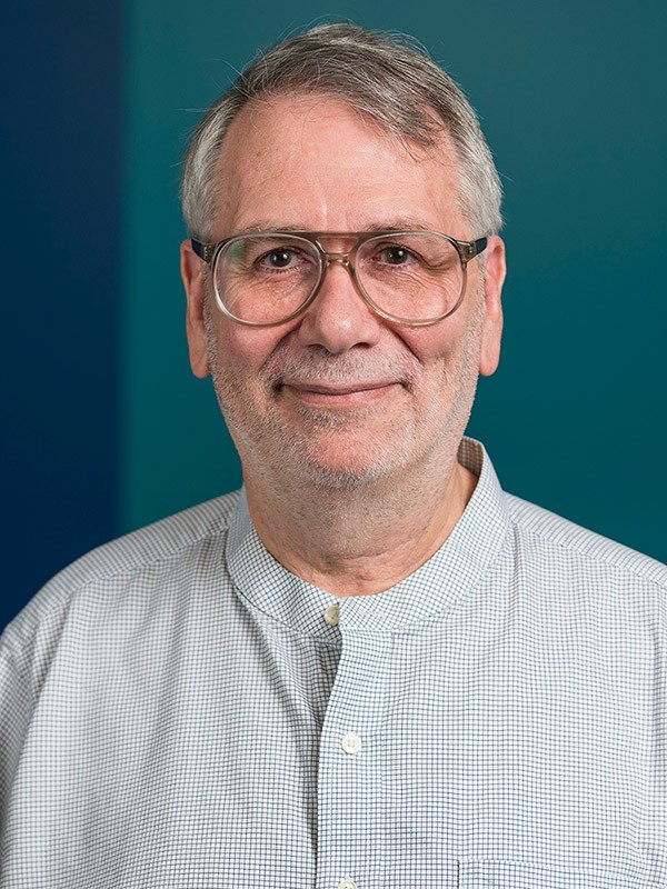 A photo of Dr. Walter Jamieson in front of a blue background