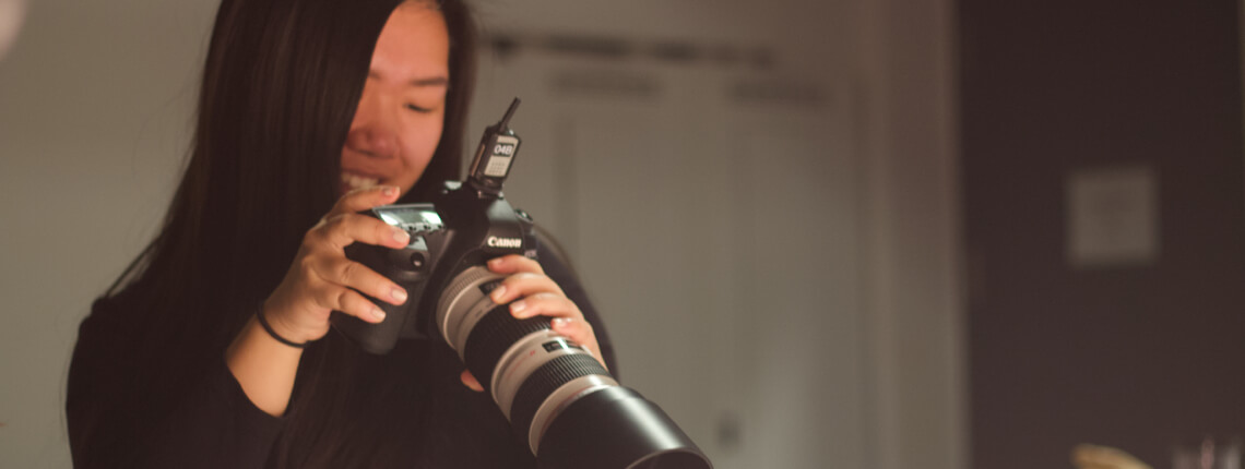 Student holding camera and adjusting settings