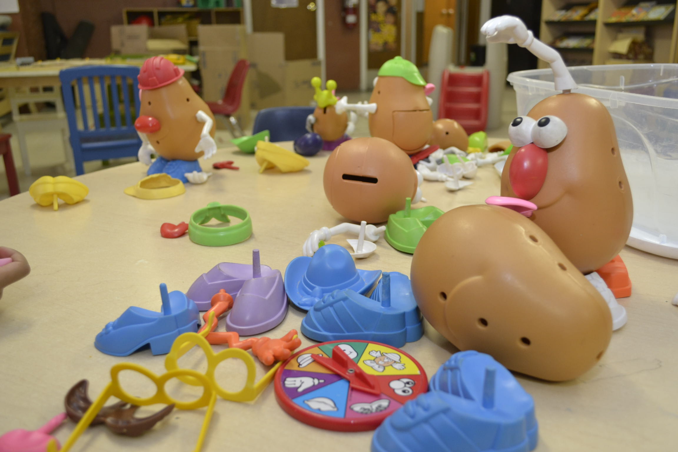 Various children's toys are scattered across a desk in a childcare centre. 