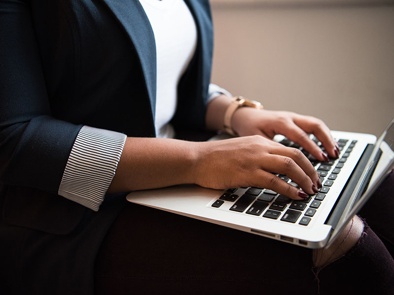 A student typing on a laptop during the online Writing Circle event