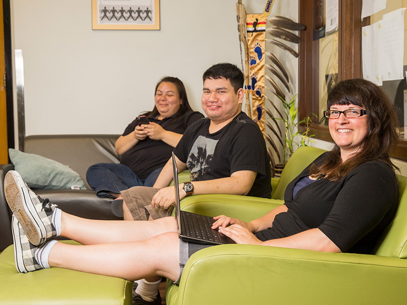 Three Indigenous TMU community members sitting on couches.