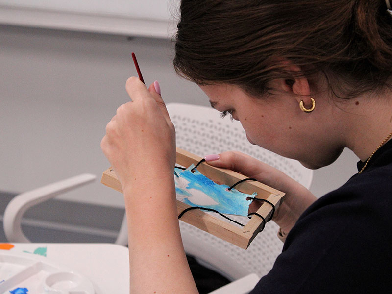 A participant painting artwork at the 2025 NIPM Inuit culture and art event.