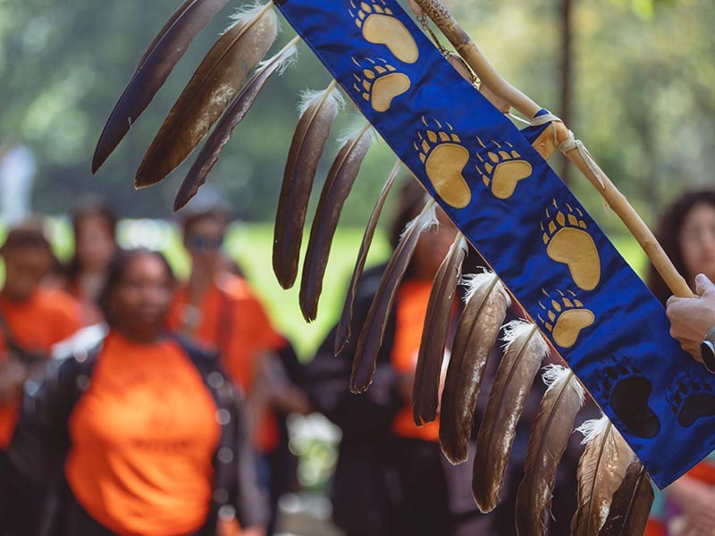 Members of the TMU community at the 2023 memorial walk. At the front of the group, a staff member holds the TMU Eagle Staff.