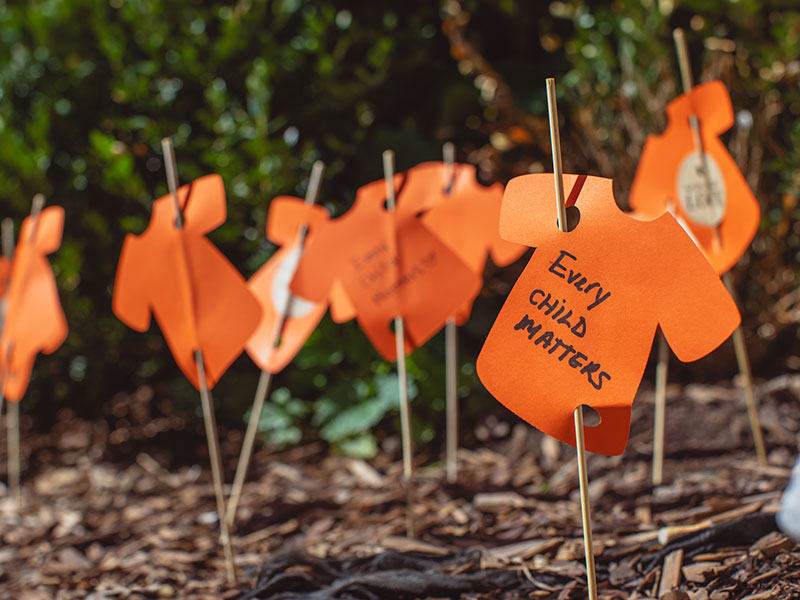 Paper cut out of t-shirts with print saying "Every Child Matters"