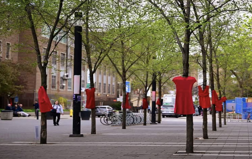 red dresses hanging from trees on campus