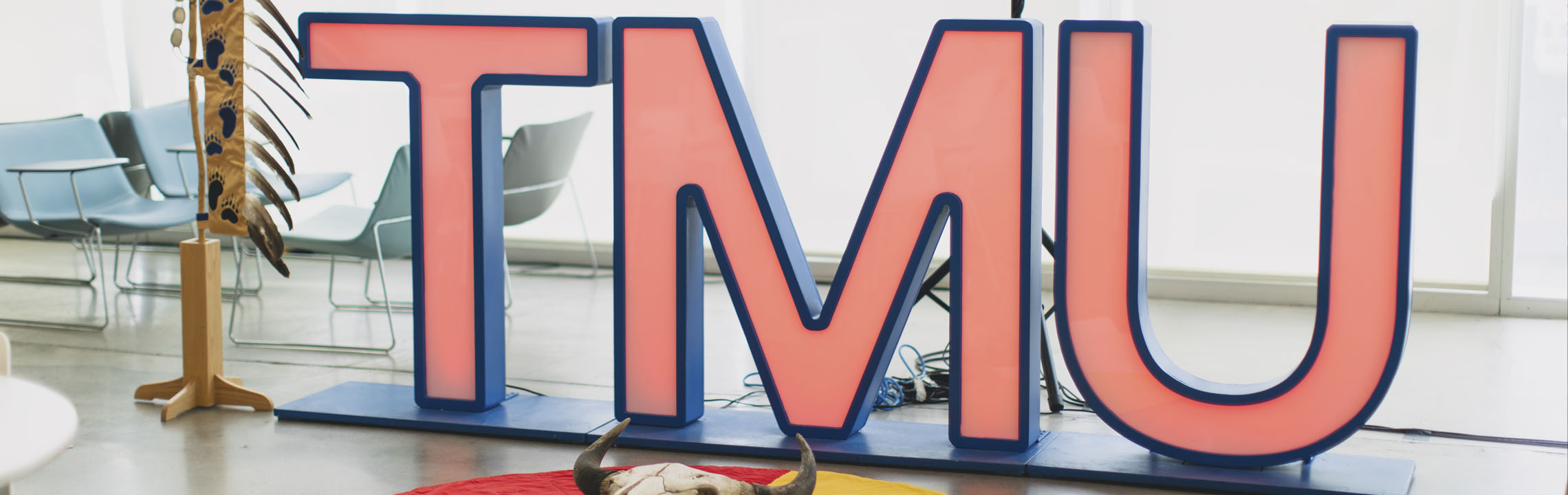 TMU sign with indigenous items at ceremony