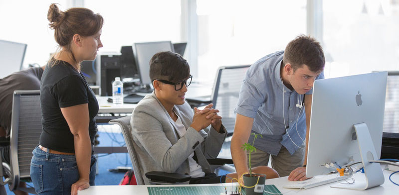 3 students working together in a computer lab 