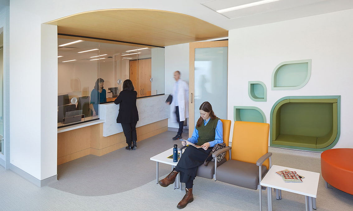 Architectural rendering of the TMU Integrated Health Centre reception desk and waiting area with modern seating and decorative wall niches.