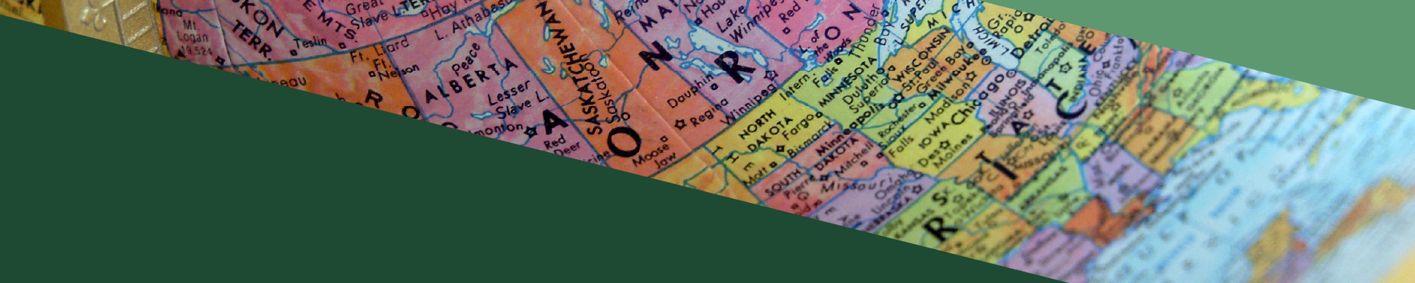 Close-up of a globe with green triangles in the bottom-left and top-right corners