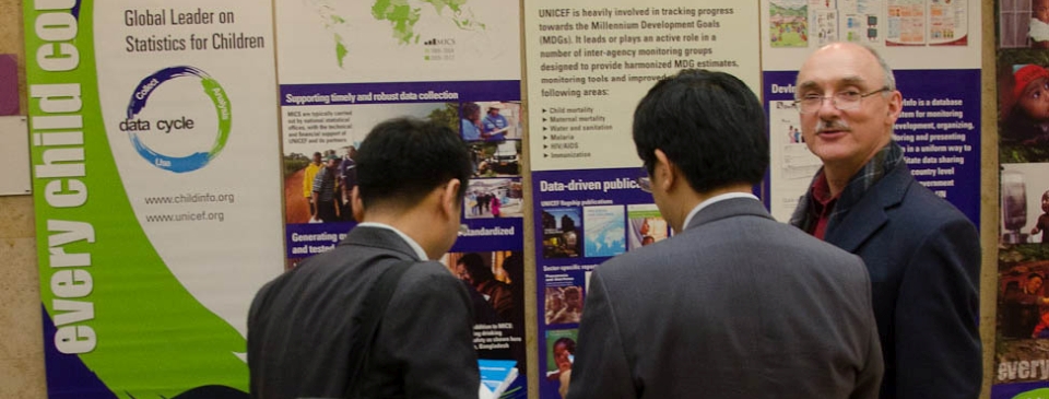 Three attendees looking at a Every Child Counts booth setup by the UNICEF at the ISCI confrence