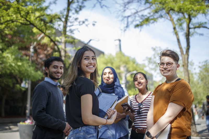 Group of students smiling outside of Kerr Hall quad