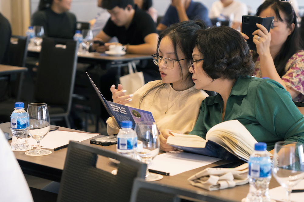 A student and a parent looking at a TMU brochure.