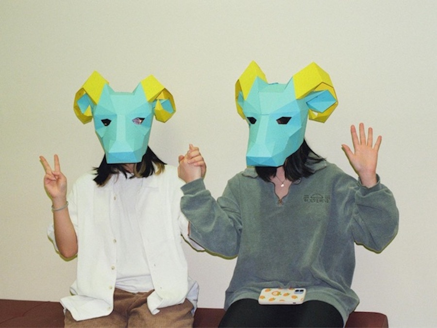 Rena and a friend posing for a photo wearing blue ram masks 