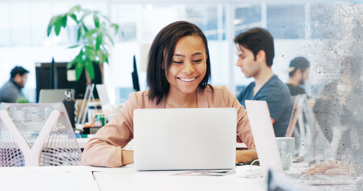 Happy student looking at a laptop screen