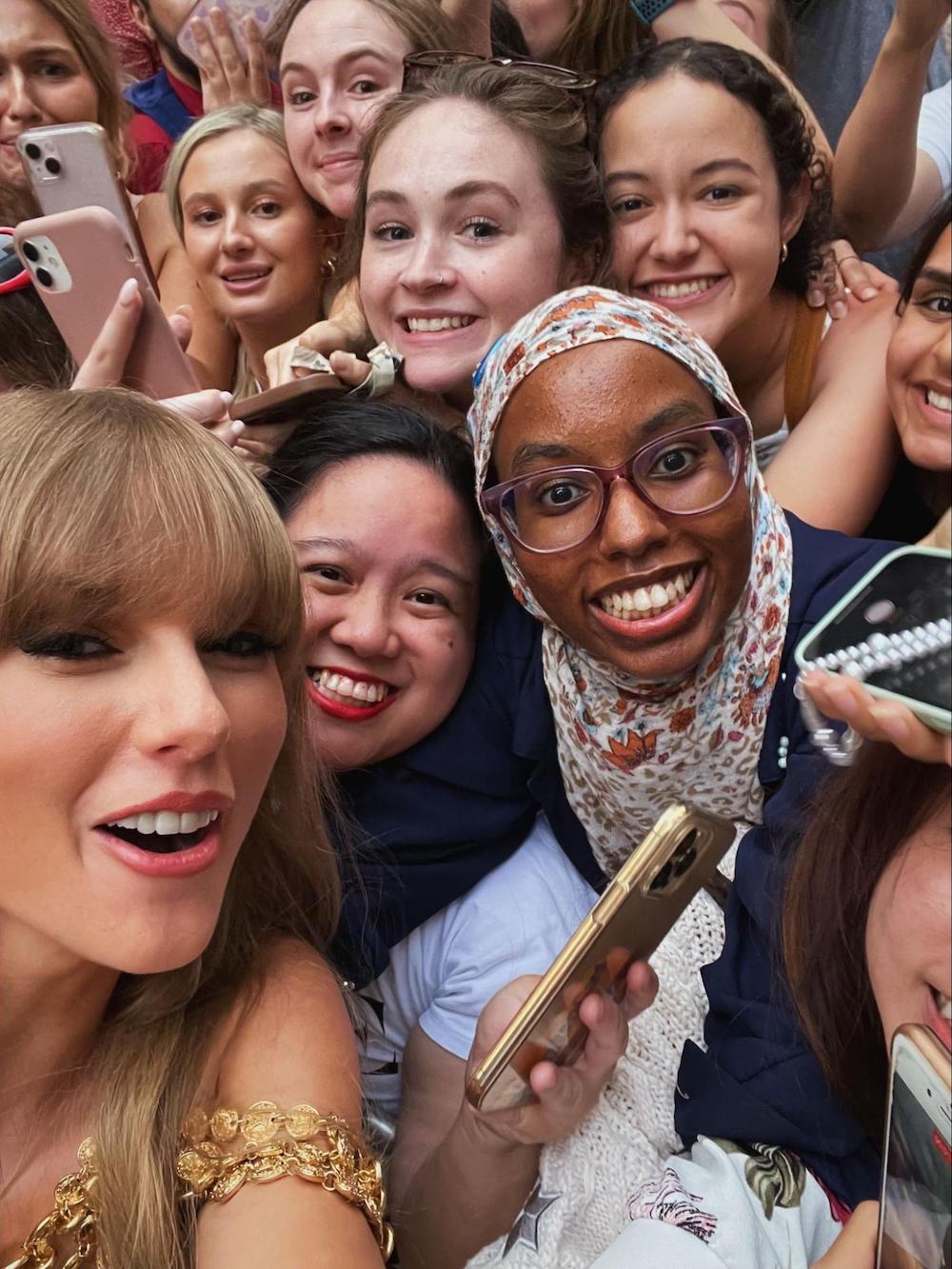 Giuli and her friend taking a selfie with Taylor Swift among a crowd of fans