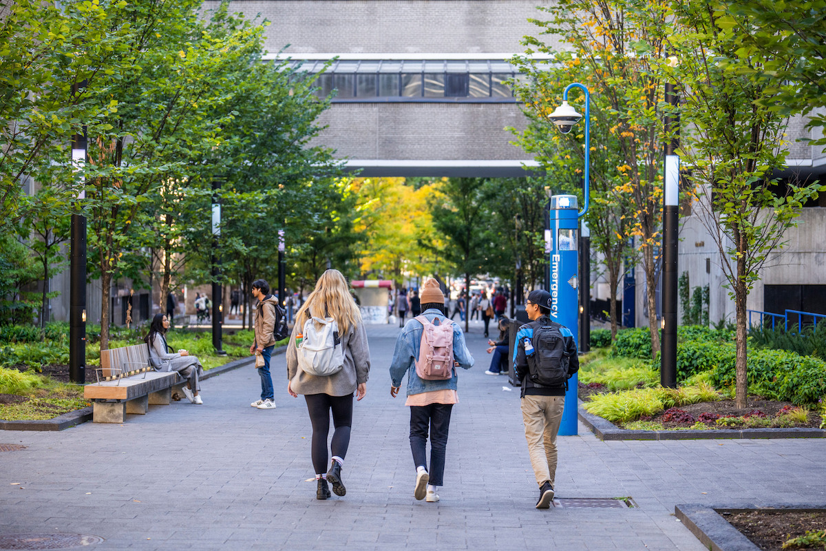 Three students walking on TMU campus.