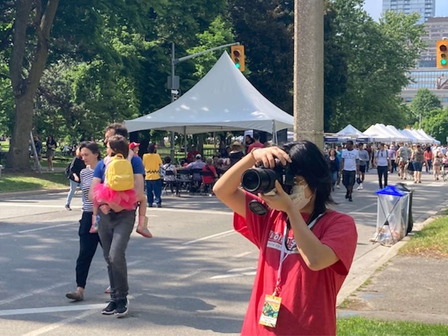 Rena holding a camera and taking photos during orientation week.