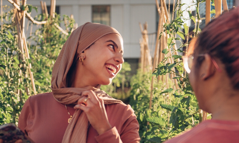 A student is smiling and looking at a third person not pictured. 