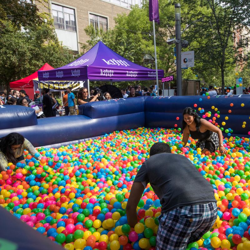 TMU students play around in a ball pit during a campus event.