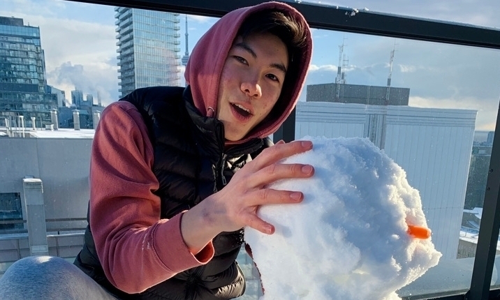 A student is building a snowman. 