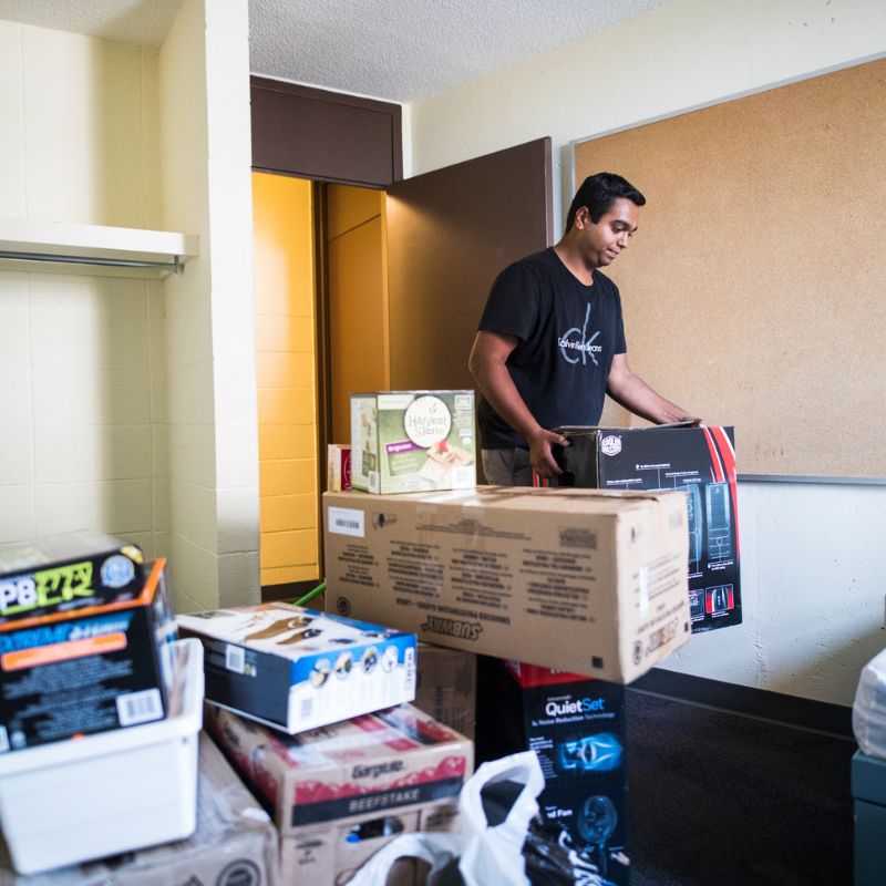 A TMU student carries his boxes into his dorm in Pitman Hall.