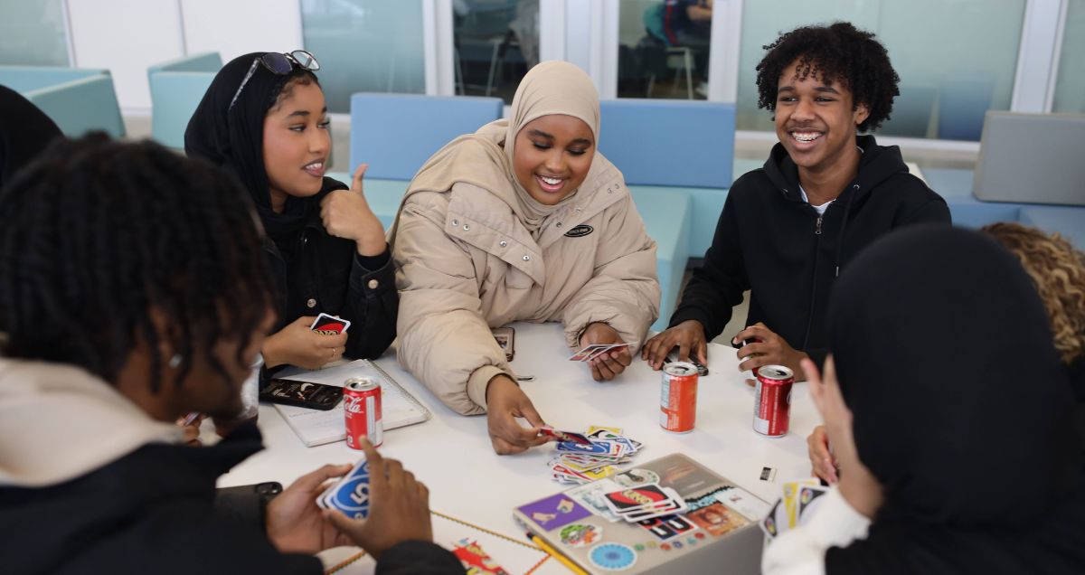 A group of Black students sitting at a table chatting