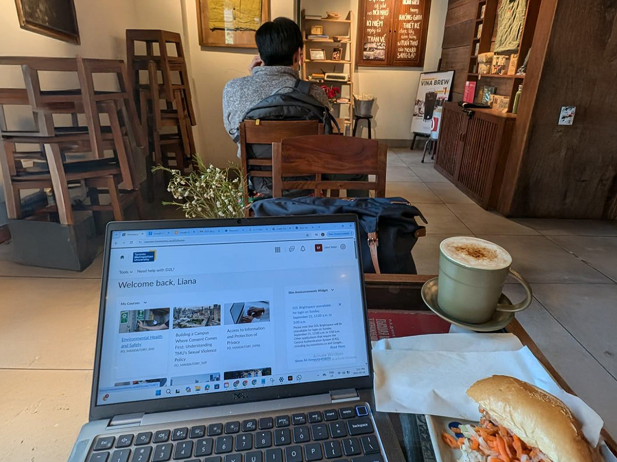 University webpage open on a laptop in a cafe