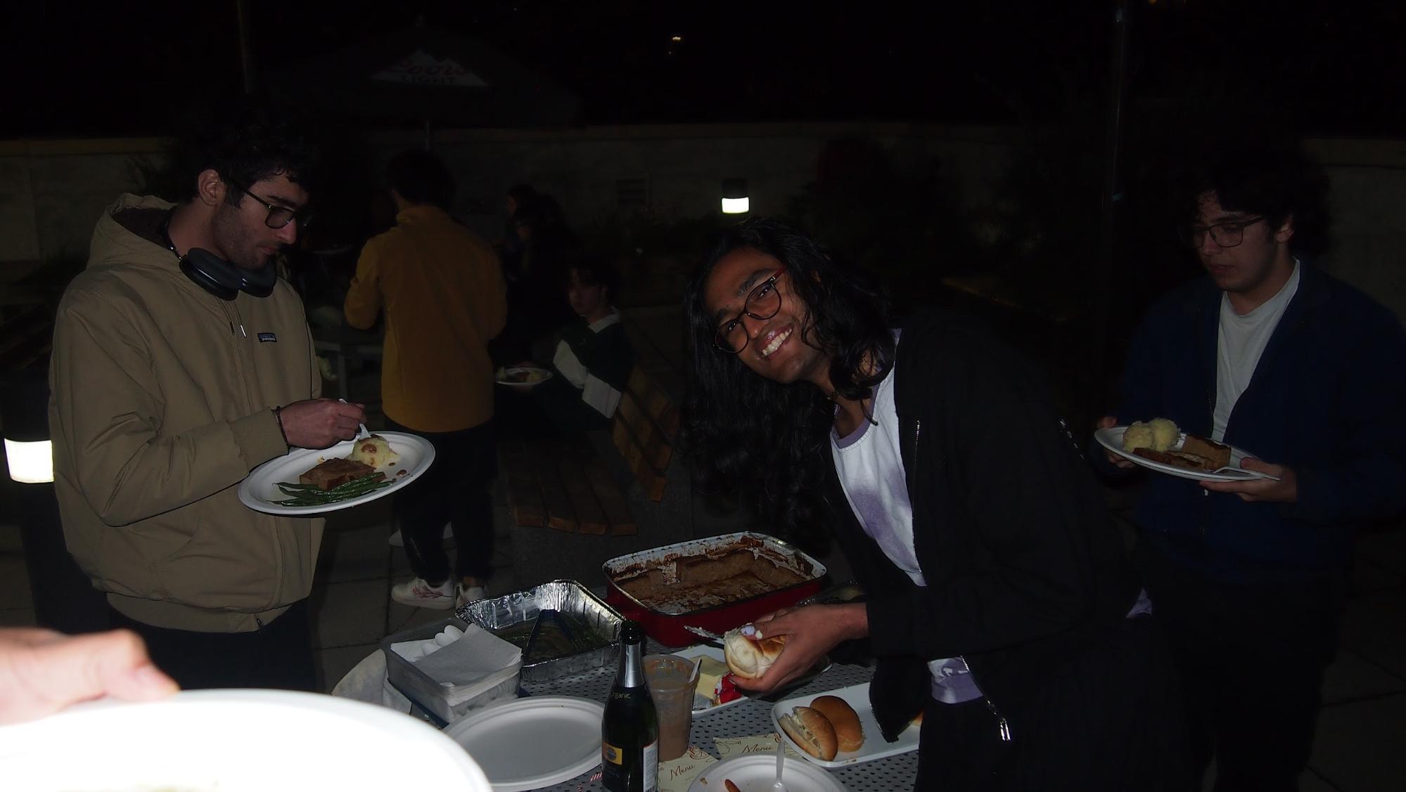 Friends gathered around a dinner table celebrating Friendsgiving with food and drinks