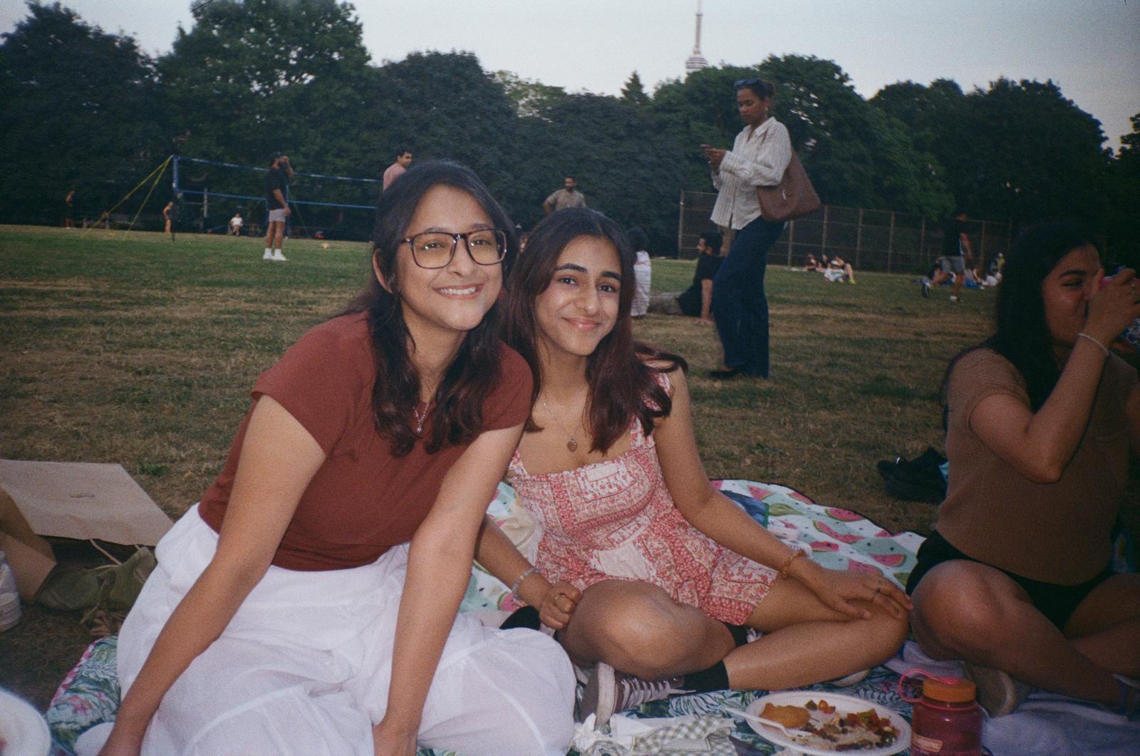 Two students in Trinity Bellwood Park in Toronto on a picnic